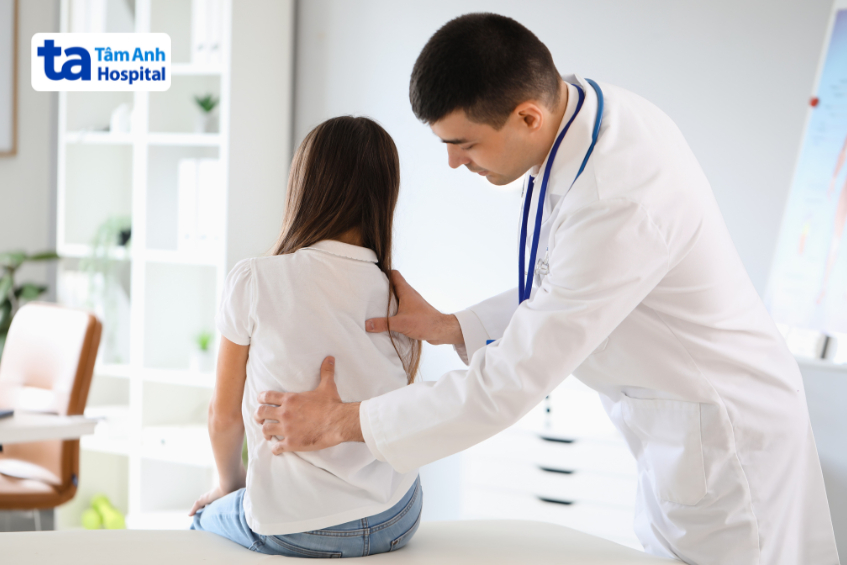Bác sĩ khám cho bệnh nhi bị cong vẹo cột sống