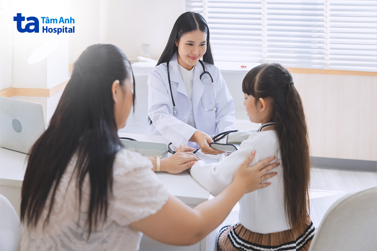 Bác sĩ thăm khám nội tiết cho bé gái cùng phụ huynh.
