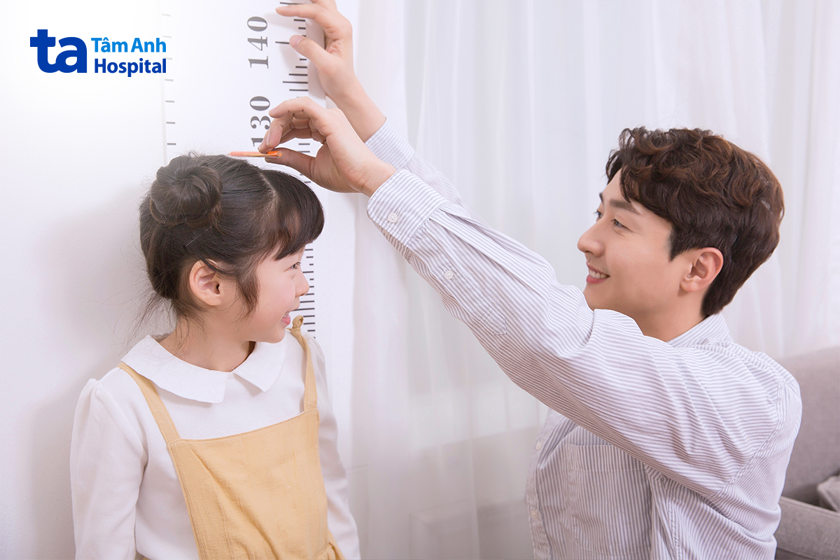 Người bố đo chiều cao để theo dõi sự phát triển của con gái