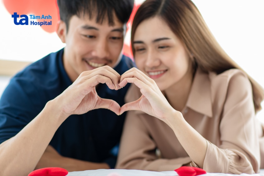Cặp đôi tạo hình trái tim bằng tay trong không gian lãng mạn.