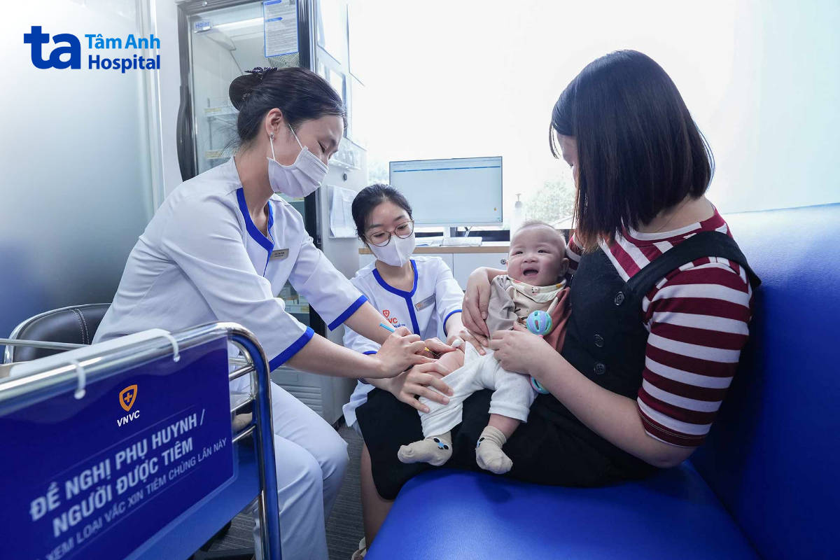mẹ bế em bé chích ngừa