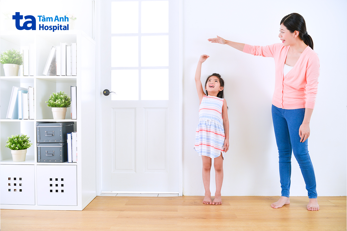 Người mẹ quan sát và so sánh chiều cao của con gái