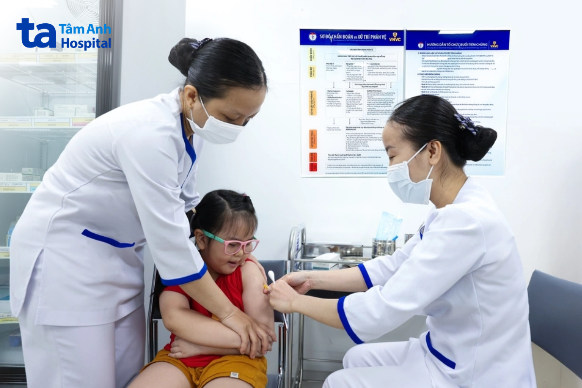 nhân viên chích vắc xin cho bé gái