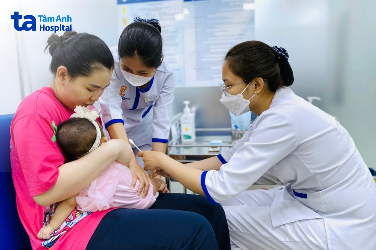 nhân viên chích vắc xin cho em bé