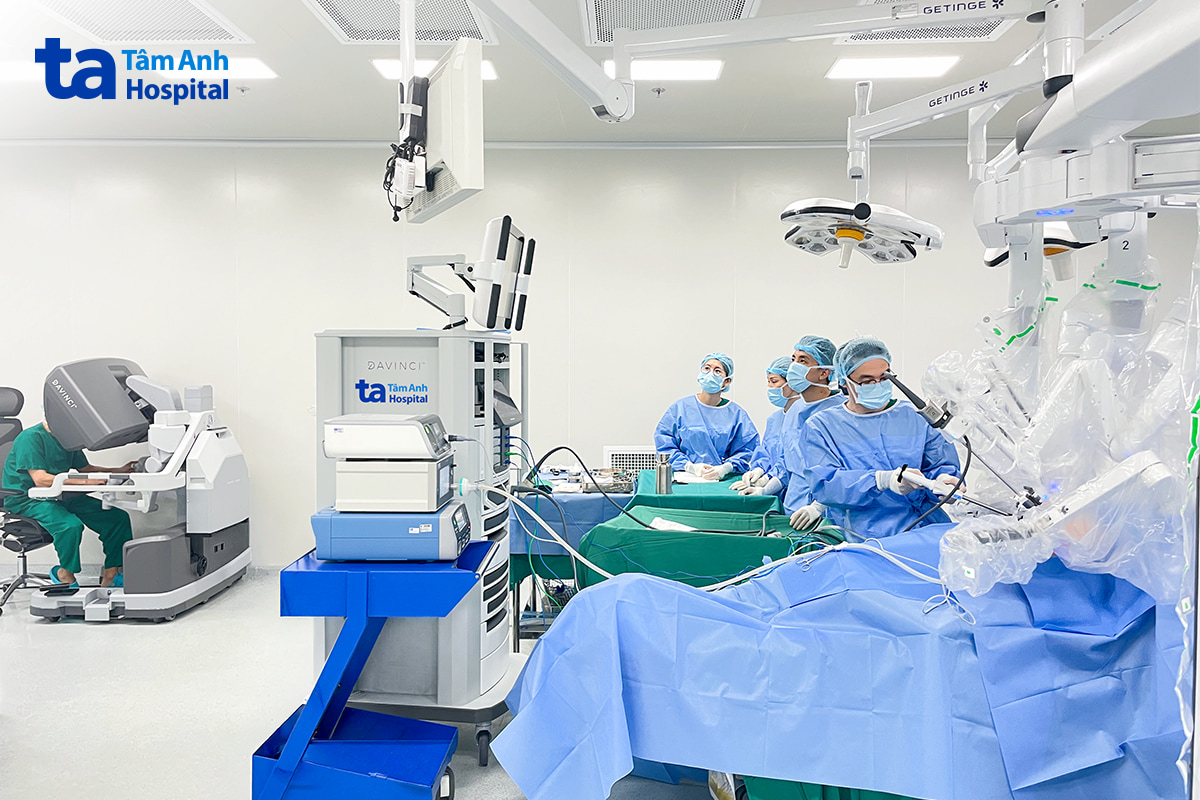 Phó giáo sư Vĩnh (bên trái) điều khiển robot thế hệ mới phẫu thuật u trung thất ở vị trí phức tạp cho người bệnh