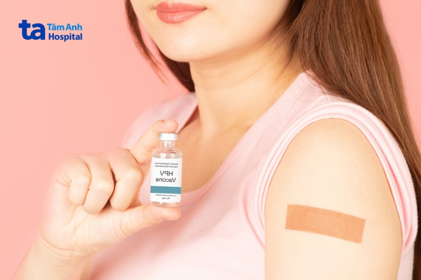 Phụ nữ cầm lọ vắc xin HPV sau khi tiêm phòng.