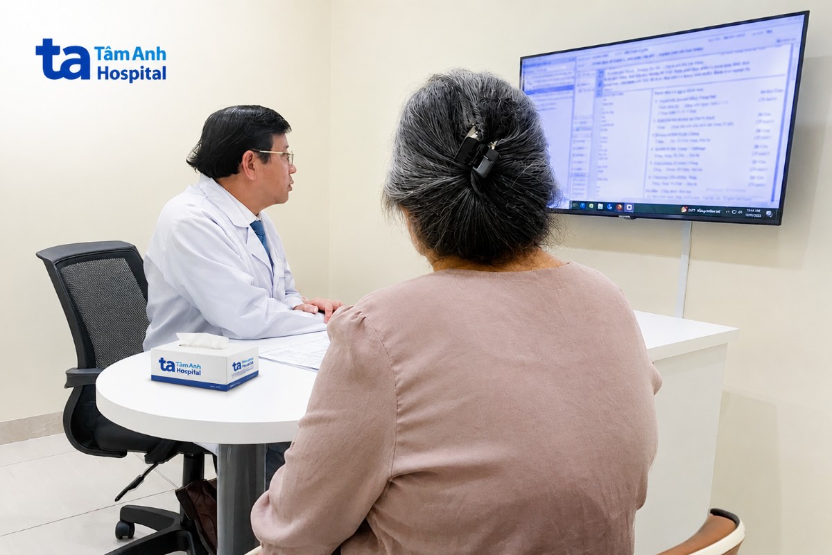 bác sĩ đang kiểm tra các chỉ số khi bà bệnh nhân đến tái khám