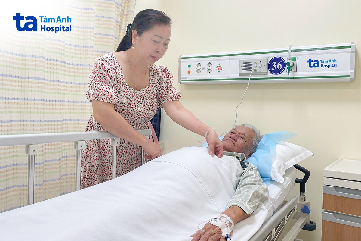 chị thu trò chuyện và chăm sóc ông tuấn khi đang truyền dịch