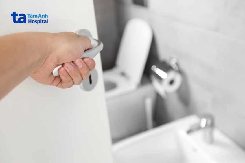 Người dùng mở cửa bước vào nhà vệ sinh công cộng.