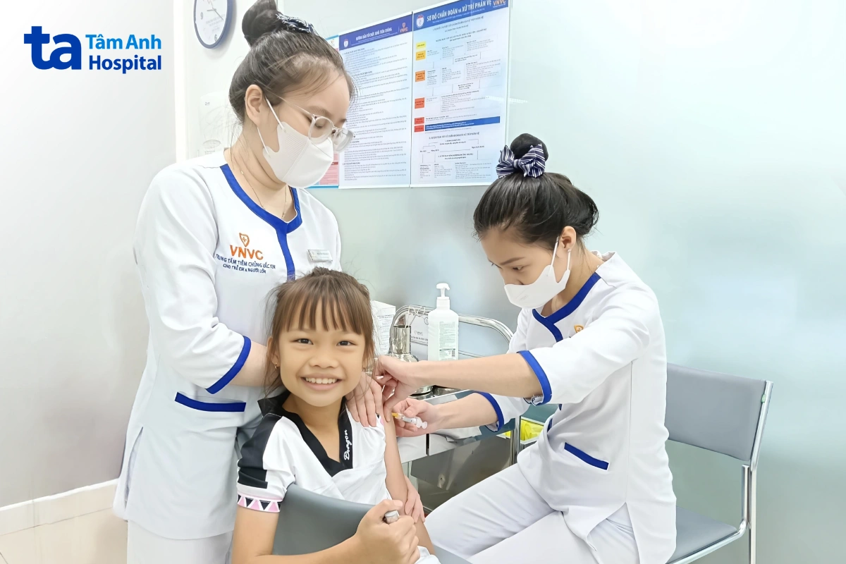 nhân viên y tế tiêm cho bé gái