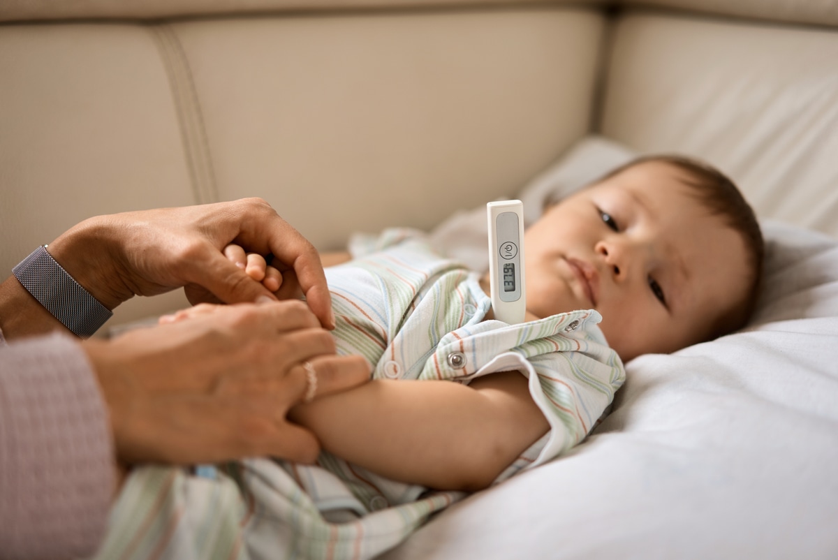Mẹ đo nhiệt độ cho bé bị sốt, tay chân lạnh