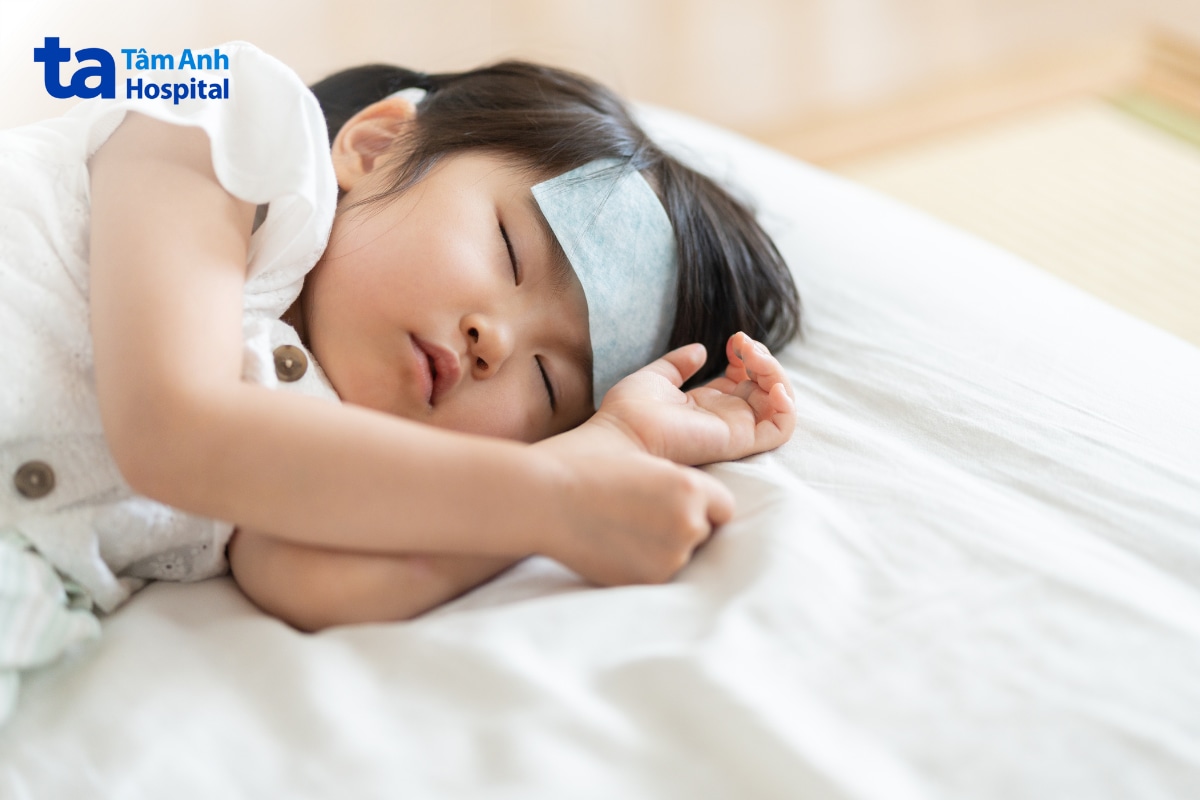 Trẻ bị sốt nằm nghỉ với khăn mát trên trán