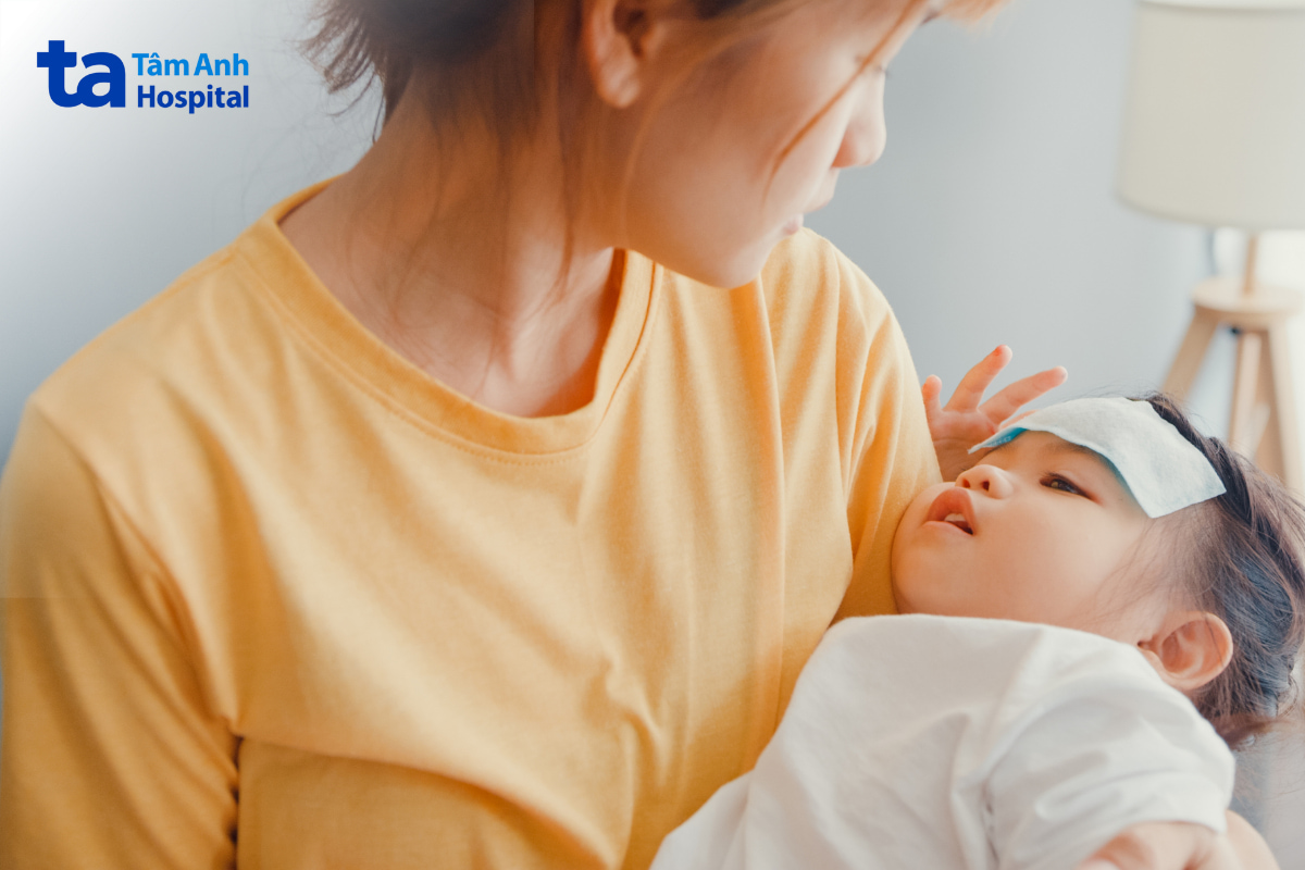 Mẹ chăm sóc trẻ bị sốt sau khi tiêm phòng