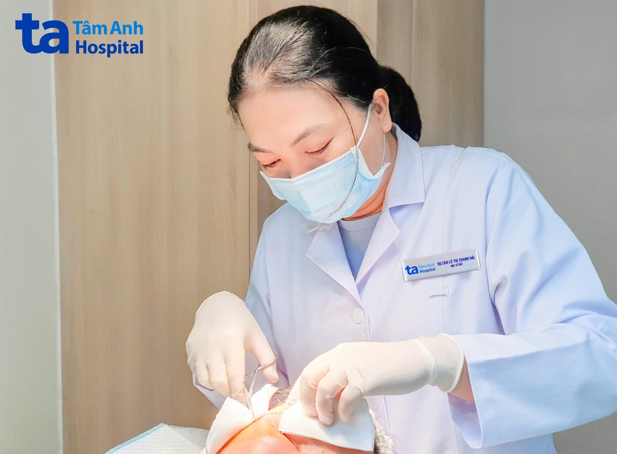 bác sĩ đang kiểm tra, vệ sinh vết mổ của bệnh nhân