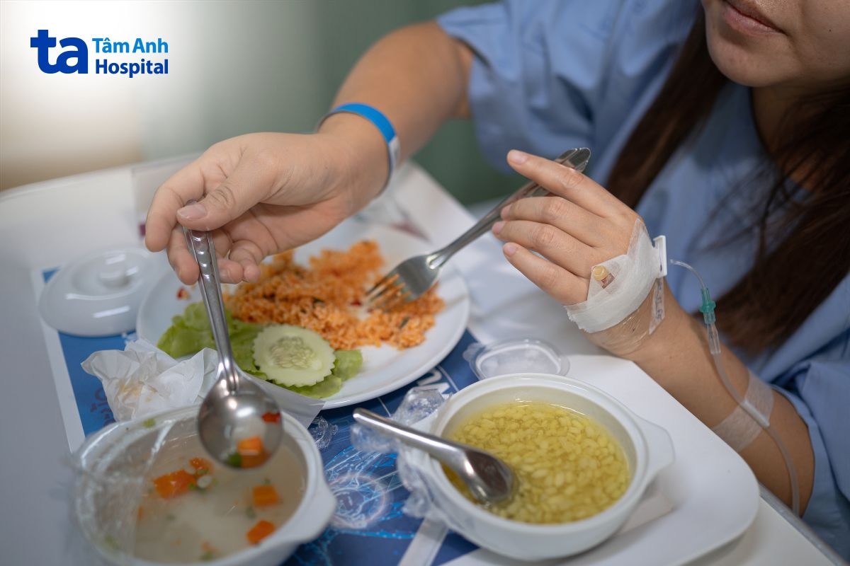 Người bệnh dùng bữa tại giường trong khi đang có đường truyền tĩnh mạch.