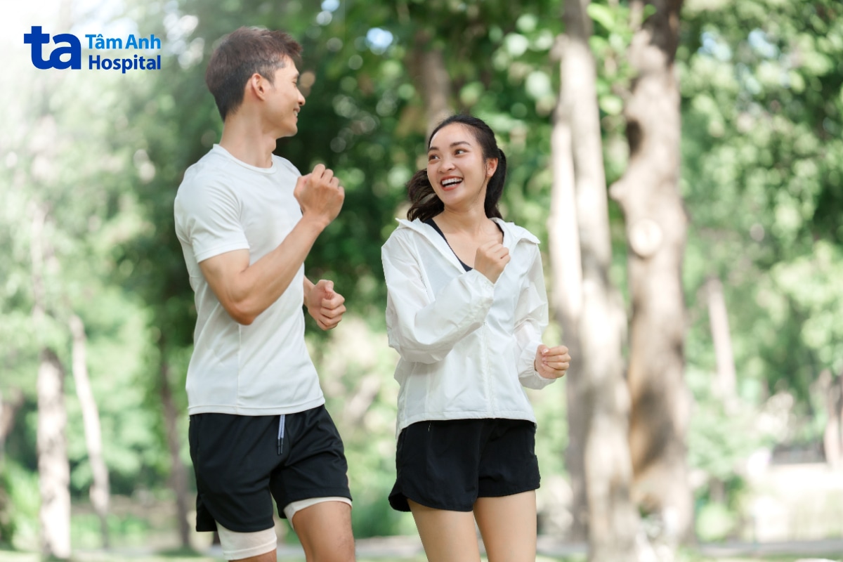 Nam nữ chạy bộ ngoài trời trong không gian xanh.