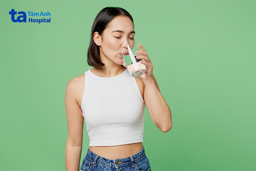 Người phụ nữ uống nước để duy trì thói quen sinh hoạt lành mạnh.