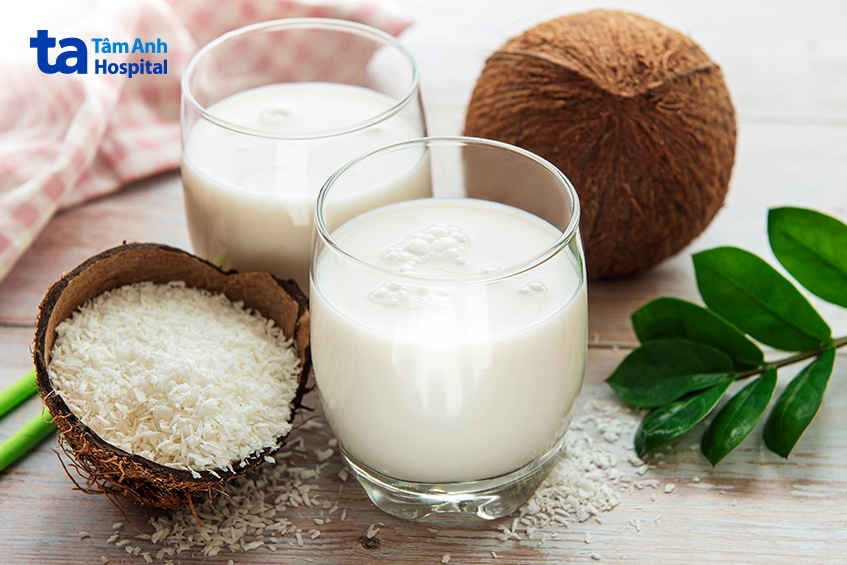 Ly Nước Cốt Dừa Đặt Cạnh Quả Dừa Tươi Và Cơm Dừa Nạo.