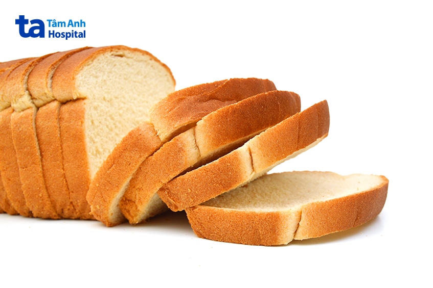 Ổ bánh mì trắng được cắt thành nhiều lát trên nền trắng.