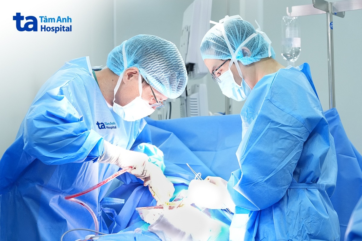 Phó giáo sư Vĩnh (bên trái) cùng êkíp phẫu thuật cắt u nằm sâu trong khí quản cho người bệnh