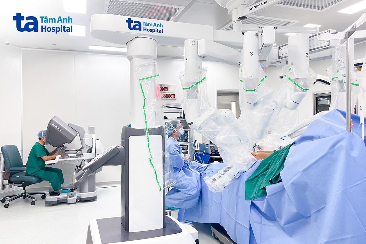 Phó giáo sư Vĩnh (bên trái) điều khiển robot Da Vinci Xi phẫu thuật cắt khối u trong lồng ngực cho người bệnh