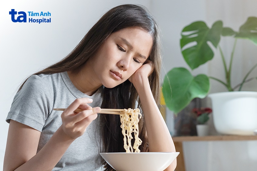 Người Phụ Nữ Tỏ Vẻ Mệt Mỏi Khi Ngồi Ăn Mì.