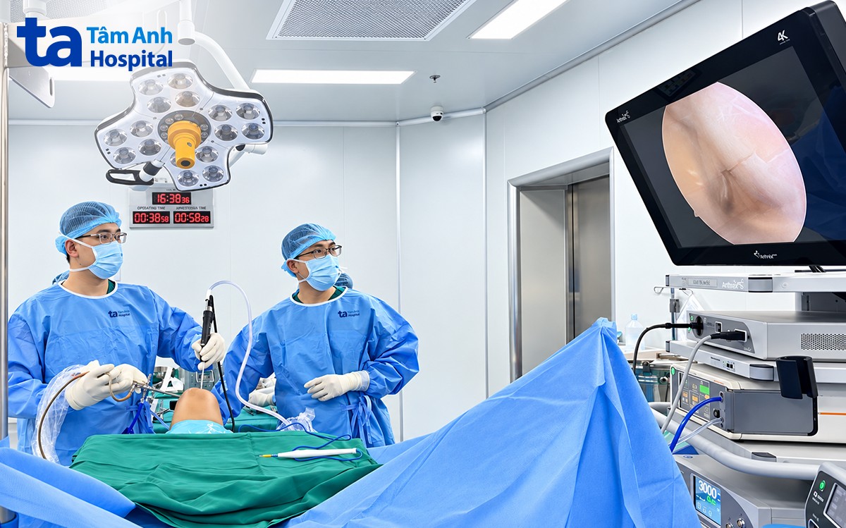 Bác sĩ Đại Dương (trái) nội soi tái tạo 3 dây chằng cùng lúc cho người bệnh.