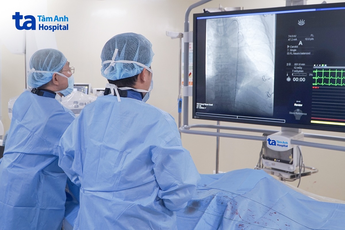 Bác sĩ Dũng (trái) cùng ê kíp đặt stent khơi thông tĩnh mạch chi dưới cho bệnh nhân
