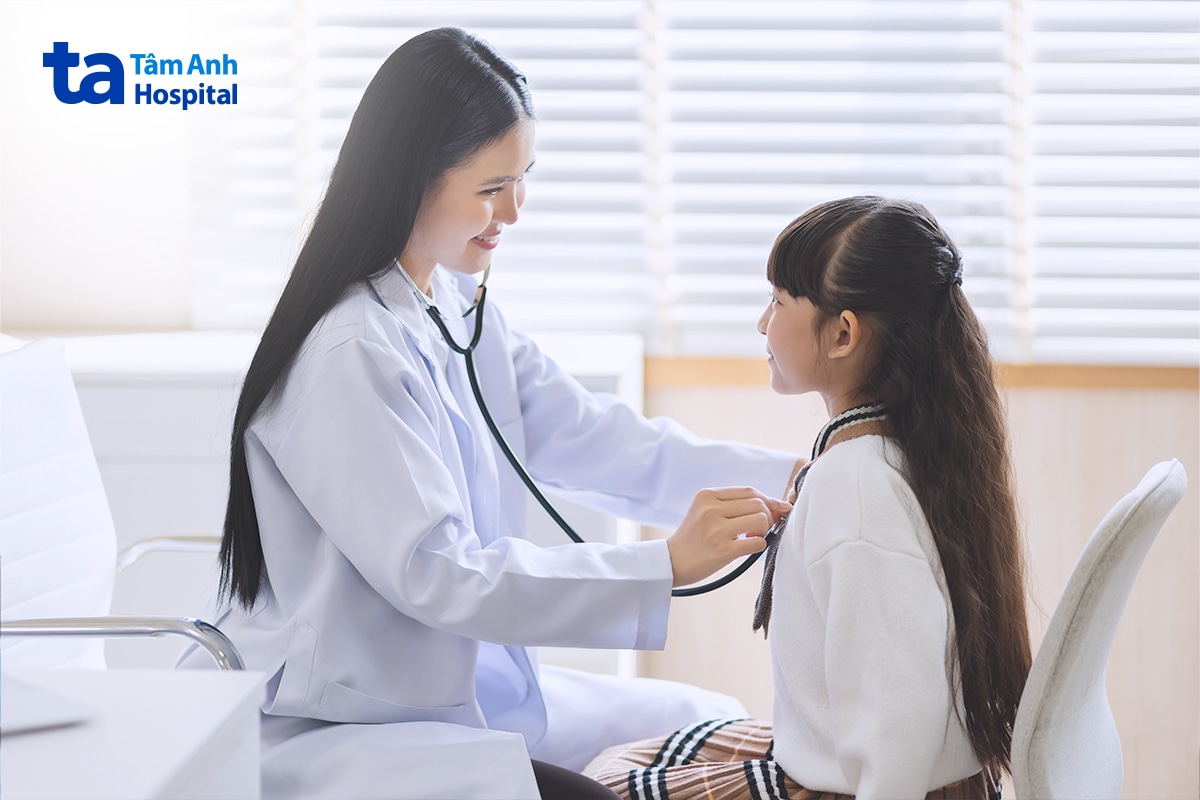 Bác sĩ dùng ống nghe thăm khám sức khỏe cho bé gái tại phòng khám
