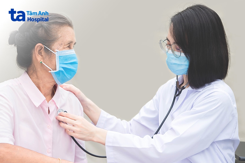 Bác sĩ dùng ống nghe thăm khám cho người bệnh lớn tuổi