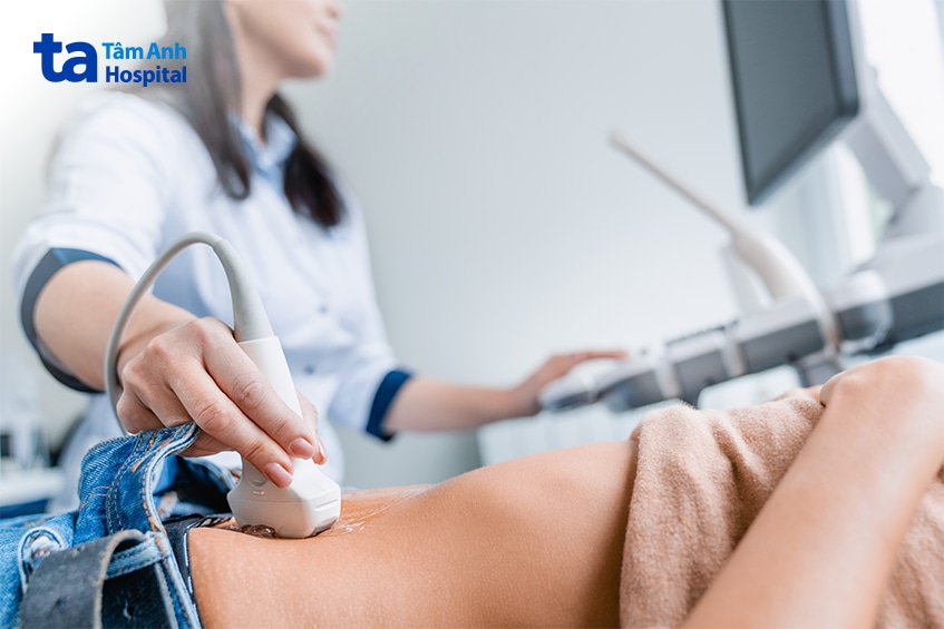 Bác sĩ di chuyển đầu dò siêu âm trên vùng bụng người bệnh
