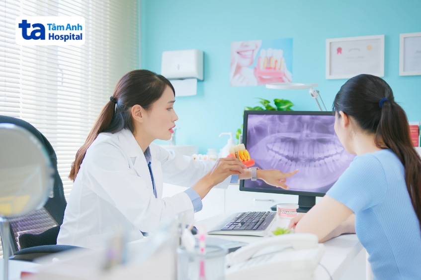 Bác sĩ nha khoa tư vấn cho bệnh nhân bên phim X-quang răng hàm