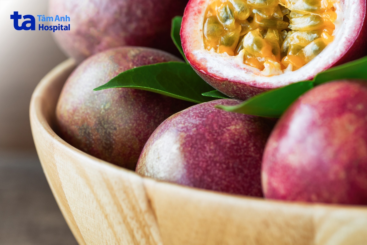 Có Bầu Uống Chanh Dây Được Không? Uống Bao Nhiêu Là Đủ? Những Quả Chanh Dây Chín Trong Tô Gỗ, Một Quả Được Cắt Đôi Lộ Ruột Vàng
