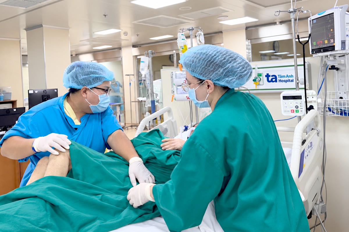 Chị Tâm (bên trái) và điều dưỡng Nhung phối hợp tắm, thay bỉm cho một người bệnh