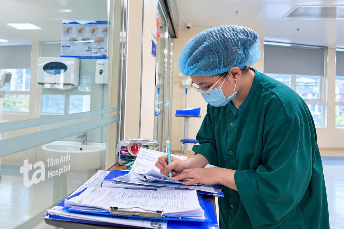Điều dưỡng Nhung đứng đối diện cửa phòng bệnh