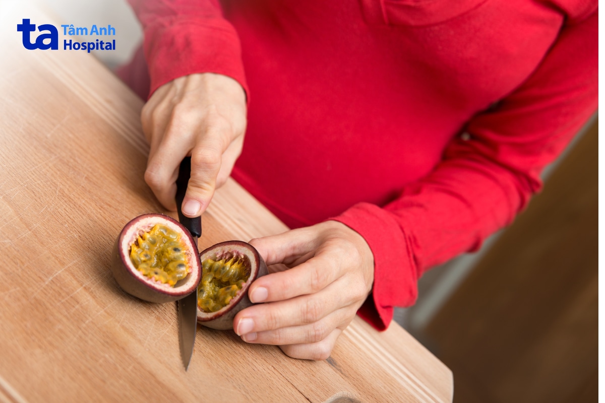 Có Bầu Uống Chanh Dây Được Không? Uống Bao Nhiêu Là Đủ? Người Mặc Áo Đỏ Dùng Dao Cắt Đôi Quả Chanh Dây Trên Bàn Gỗ